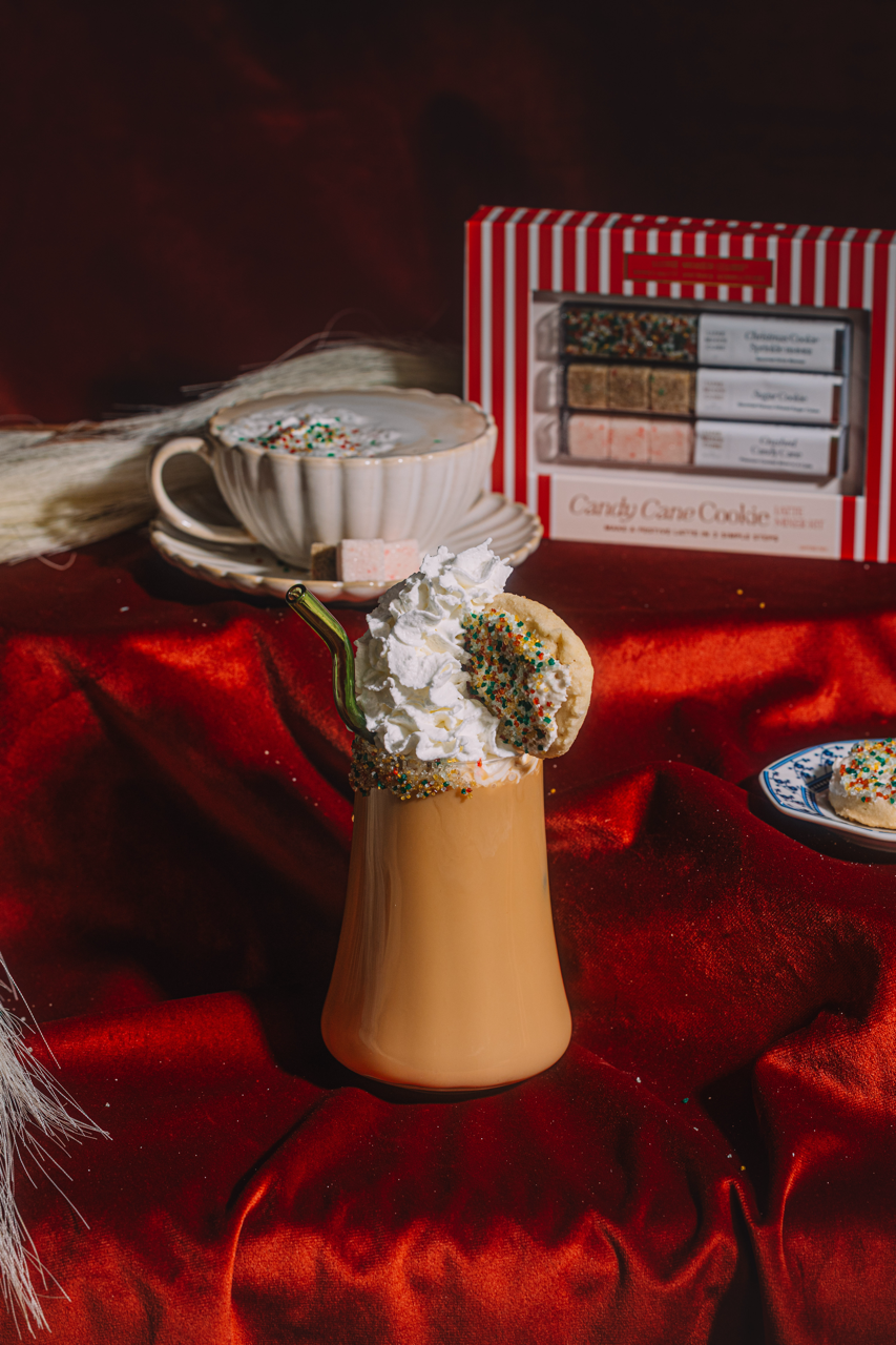 Decorative scene with a small cup, cookies, and a box on a red surface