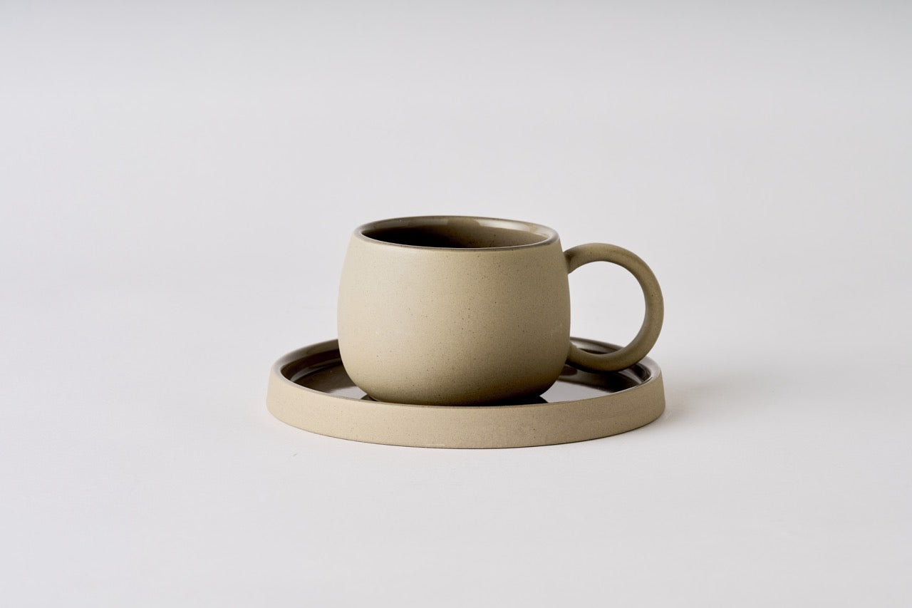 Ceramic mug with matching coaster on a light gray background