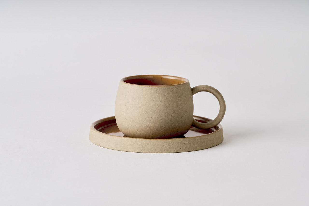 Beige ceramic mug with matching coaster on a light gray background