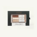 A Luxe Mixer Club by Claiborne Coffee Cafe Set in a black presentation box with a clear window showing three small coffee-flavored stick packs: Cinnamon Madness, White Chocolate Mocha, and French Vanilla.