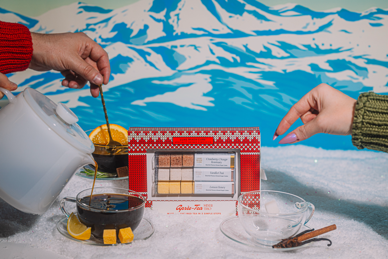 Tea-making setup with a tea set box in the center, against a snowy mountain background.