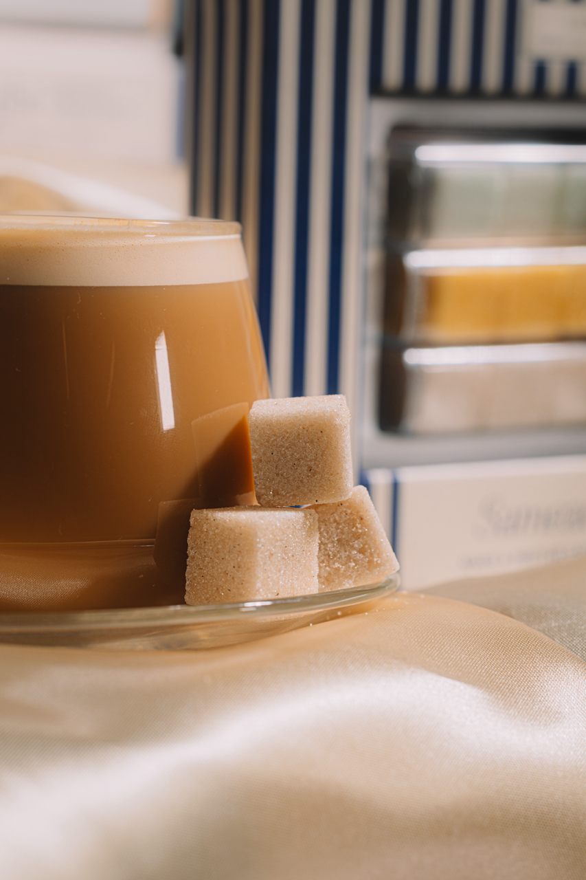 Glass of iced coffee with three LUXE Mixer Cubes on a blurred background