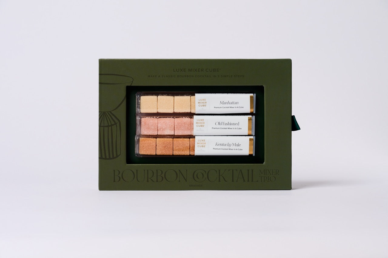 Set of bourbon cocktail mixers in a green box on a light gray background