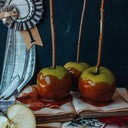 Caramel apples on sticks with a ribbed award on an open book